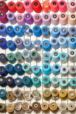 Bobbins of sewing thread in various colors.