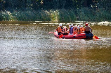 Bir yaz günü, nehirde şişme bir teknede turist raftingi. Boşluğu kopyala.