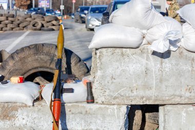Kyiv 'de bir şehir caddesine inşa edilmiş beton kontrol noktasının arka planına karşı bir tanksavar bombası fırlatıcısı..