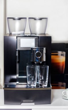 İki boş bardak kahve makinesinin yanında duruyor. Boşluğu kopyala.