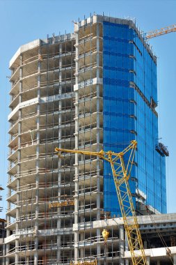 Construction and glazing of a new residential multi-storey building using winches and suspended platforms.
