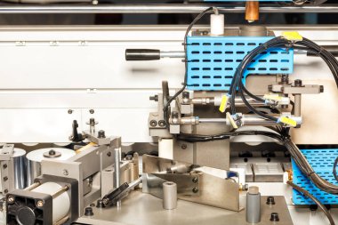 Otomatik bir makinenin güç bloğunun mekanizmasını kabine mobilyası üretimi için ayarlıyorum. - Yakın çekim. Boşluğu kopyala.