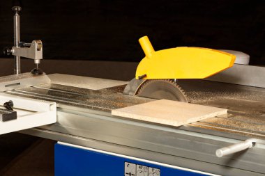 Dolap mobilyası üretimi için testerenin üzerinde ayarlanabilir geri çekilebilir bir mekanizmaya sahip bir testere bıçağı. Uzayı kopyala Yakın plan..