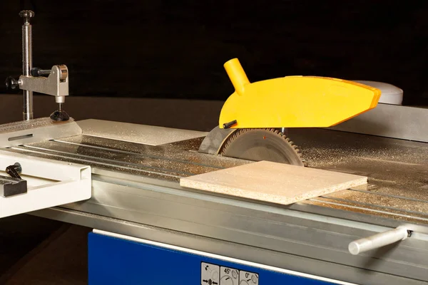 Dolap mobilyası üretimi için testerenin üzerinde ayarlanabilir geri çekilebilir bir mekanizmaya sahip bir testere bıçağı. Uzayı kopyala Yakın plan..