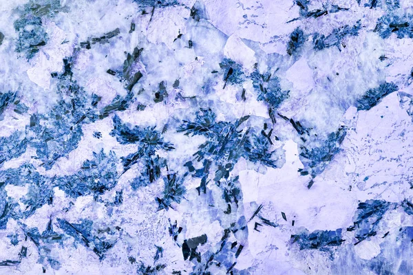 Marble texture of crystals of blue, purple marble with black inclusions, with various inclusions and veins.