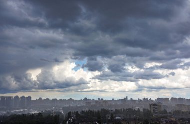 Yoğun bir halıda asılı gri gök gürültülü Kyiv 'in üzerine sağanak yağış.