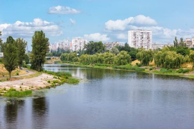 Kyiv, Rusanivka 'da bir yaz günü Dinyeper bankalarının yeşilliği. Arka planda eski gökdelenler var. Yaz mevsiminde manzara.