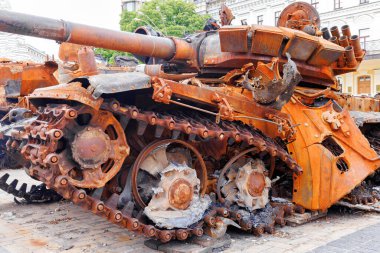 Destroyed rusty Russian tank in the open air on the city square. Active phase of the war with russia. clipart