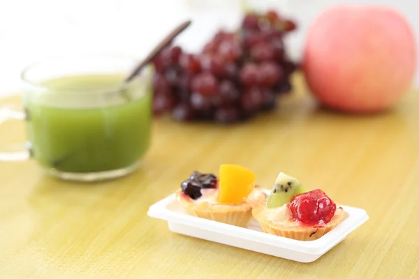 Tarta de frutas con té verde sobre fondo de madera — Foto de Stock