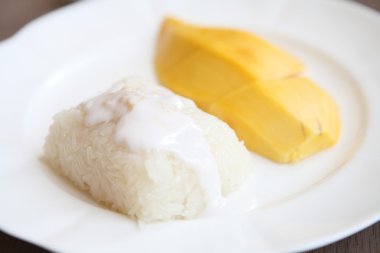 Ahşap zemin üzerinde mango olan yapışkan pirinç.
