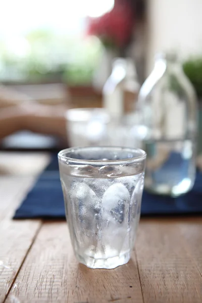 Vatten i glas i trä bakgrund — Stockfoto