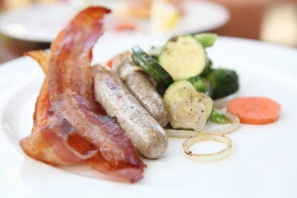 Smažené slaniny a klobásy se zeleninou — Stock fotografie
