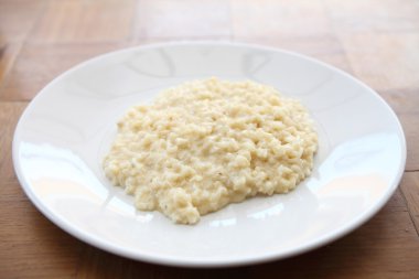 Ahşap arka planda otlu risotto tabağı