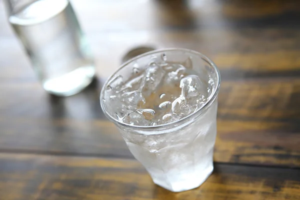 Agua en vidrio en fondo de madera — Foto de Stock