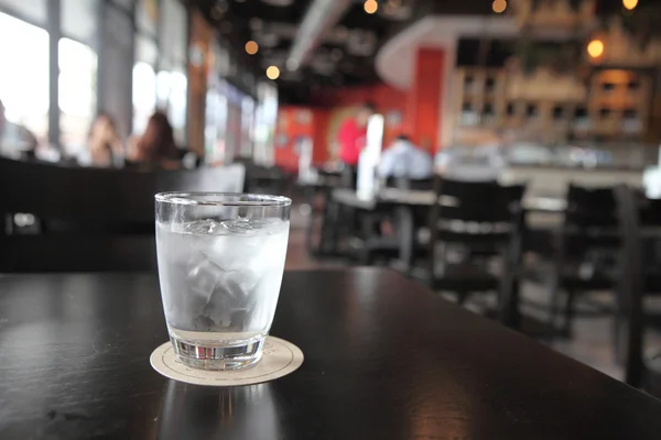 Agua en vidrio en fondo de madera — Foto de Stock