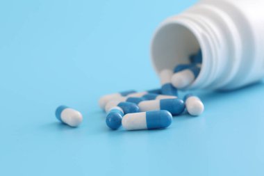 Mavi arka planda izole edilmiş şişe kapsülleri