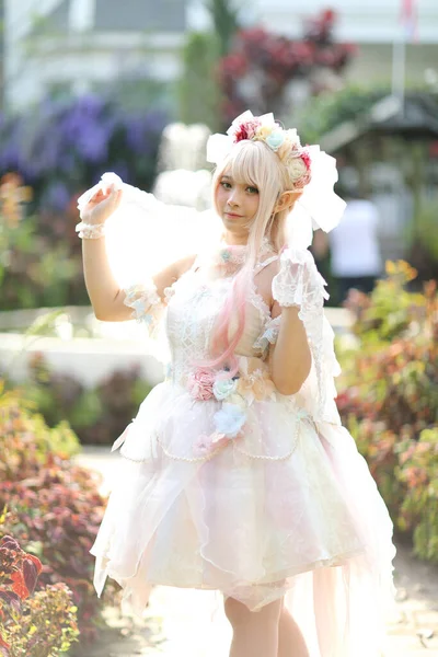 漂亮的年轻女子 穿着白色的罗莉塔礼服 花草花园 日本时尚 — 图库照片