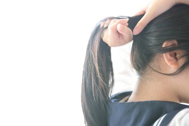 Beyaz odadaki Asyalı liseli kızın boynuna yakın çekim