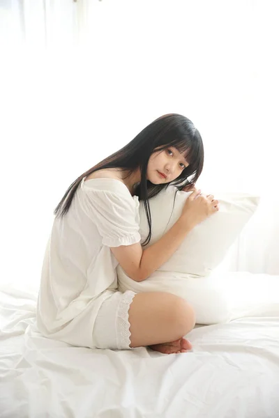 Güzel Genç Asyalı Yastıkla Yatakta Oturuyor Sabah Işığında Dinleniyor Beyaz — Stok fotoğraf