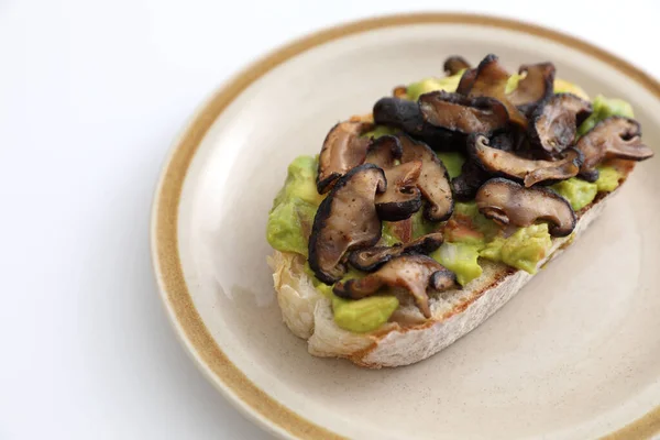 Toast with avocado and grilled mushroom in white background
