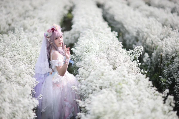 漂亮的年轻女子 穿着白色的罗莉塔礼服 花草花园 日本时尚 — 图库照片