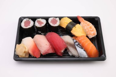 Suşi, soya soslu nigiri ve suşi sarmaları ve Japon yemek çubukları beyaz arka planda izole edilmiş.