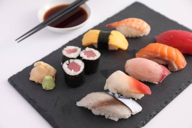Suşi, soya soslu nigiri ve suşi sarmaları ve Japon yemek çubukları beyaz arka planda izole edilmiş.