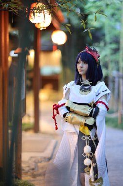 Japon genç kadın avcısı Japon bahçesinde yaylı kostüm