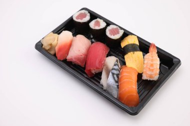 Suşi, soya soslu nigiri ve suşi sarmaları ve Japon yemek çubukları beyaz arka planda izole edilmiş.