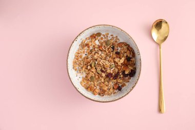 Sütlü granola pembe arka planda izole edilmiş kaşık