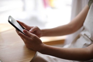 Kafede borsa alım satımı için akıllı telefon kullanan bir kadın, iş konsepti.