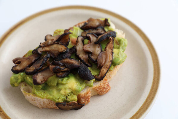 Toast with avocado and grilled mushroom in white background