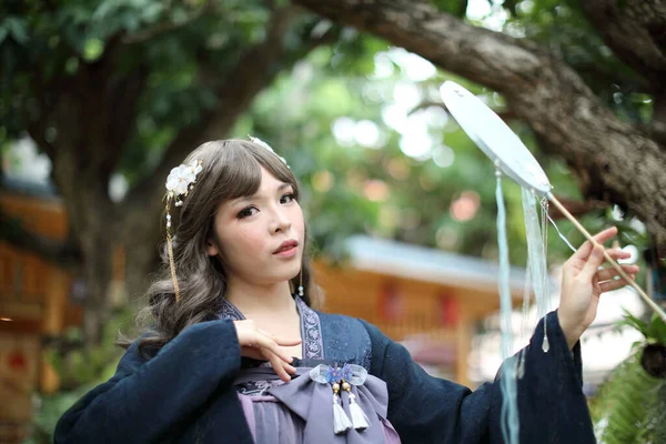美しいです若いです女性とともにダークブルー中国のロリータドレスで中国の庭 — ストック写真