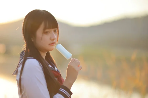 Asiatische Gymnasiastinnen Essen Eis Auf Dem Land Bei Sonnenaufgang — Stockfoto