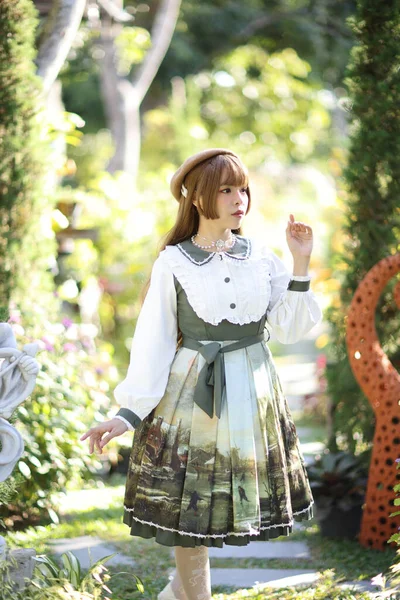 一位身穿罗莉塔长裙的漂亮女人穿着花园背景的日本街头时尚肖像 — 图库照片