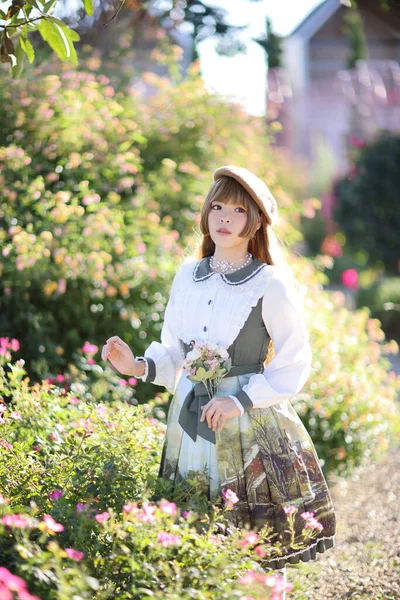 一位身穿罗莉塔长裙的漂亮女人穿着花园背景的日本街头时尚肖像 — 图库照片