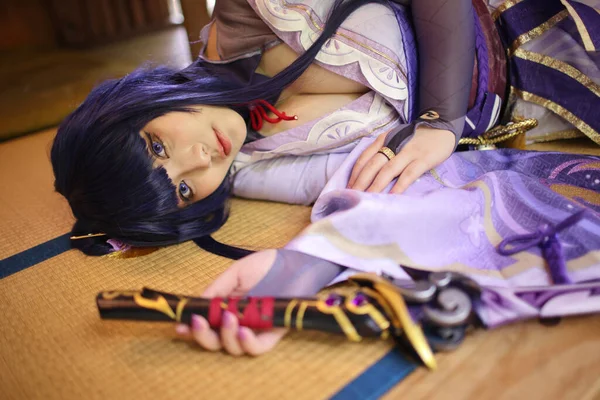 一个穿着武士服装睡在日本房间里的漂亮年轻女子游戏的肖像 — 图库照片