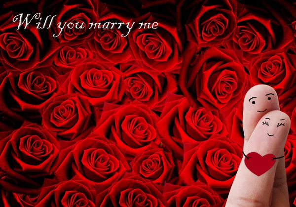 Casal feliz no amor com pintado sorridente segurando coração vermelho — Fotografia de Stock