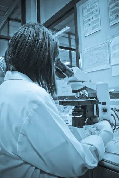 Serious clinician studying chemical element in laboratory — Stock Photo, Image