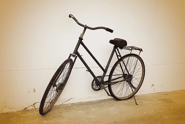 Bicicleta velha na parede da fatura — Fotografia de Stock