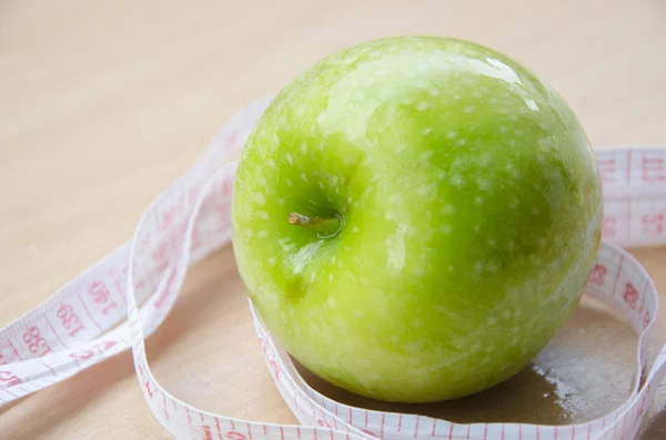 Green apple core and measuring tape. Diet concept — Stock Photo, Image