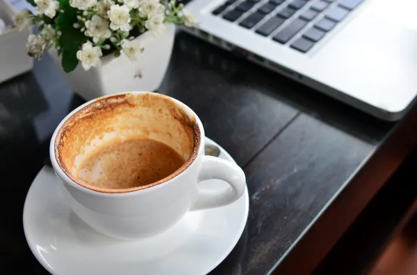 Cup of coffee and a laptop — Stock Photo, Image
