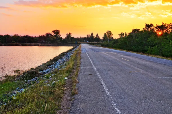 Camino rural cerca del río y bonito atardecer — Foto de Stock