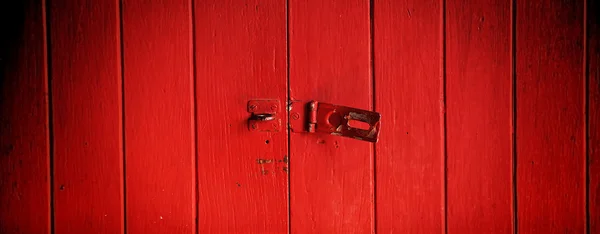 Old padlock on a red wooden door — Stock Photo, Image