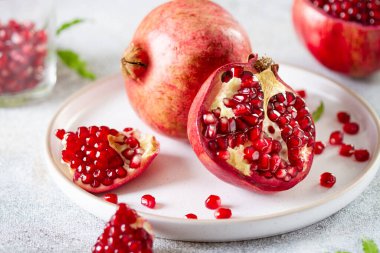 Kırık olgun narlar ve tahıllar bir tabakta yakın plan.