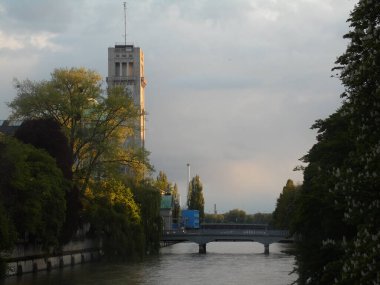Almanya 'nın Münih kentinde Isar Nehri' nin günbatımı manzarası ve Alman Bilim ve Teknoloji Müzesi von Meisterwerken der Naturwissenschaft und Technik (Alman Başyapıtları Müzesi) kulesi).