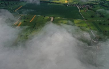 Kırsal alanlarda gün doğumu sisli tarlalar ve köyler üzerinde..