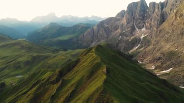Aerial video of the sunrise in the Dolomites mountains. Beautiful morning at the Seiser Alm plateau with cottages, meadows and fields. 