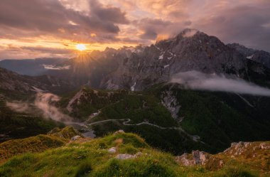Julian Alps 'te kasvetli bir sabahta dağlarda gün doğumu