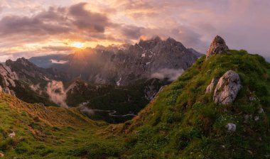 Julian Alps 'te kasvetli bir sabahta dağlarda gün doğumu